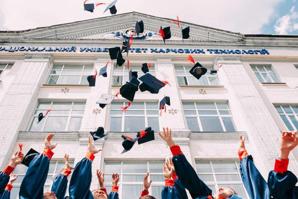 graduating students tossing their graduation caps