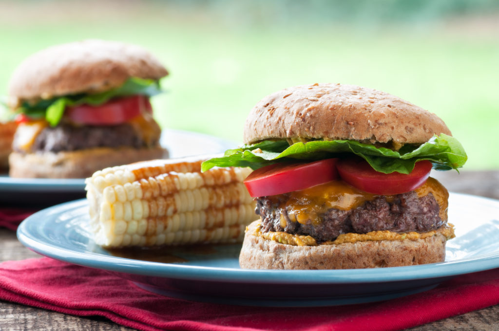 Juicy cheeseburger with grilled corn
